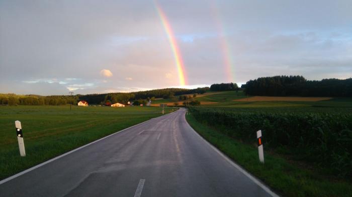 Landstraße in Richtung Illwangen mit doppeltem Regenbogen im Hintergrund